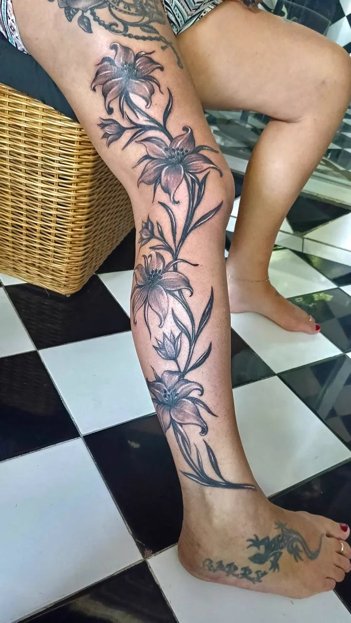 Black and Grey Lily Flower Leg Tattoo, Fine Line tattoo at Bali Family Tattoo Studio, Bali